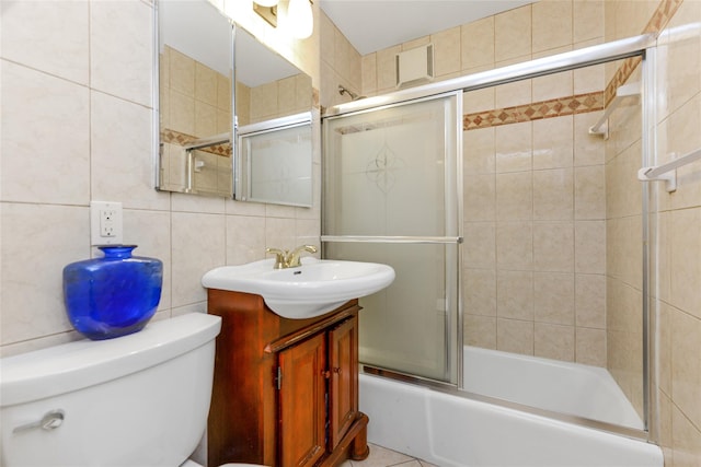 full bathroom featuring backsplash, vanity, shower / bath combination with glass door, tile walls, and toilet