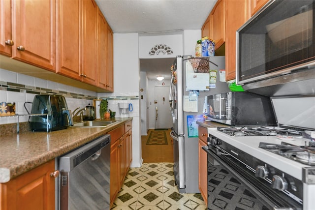 kitchen featuring sink, appliances with stainless steel finishes, and tasteful backsplash