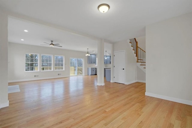 unfurnished living room featuring ceiling fan and light hardwood / wood-style floors