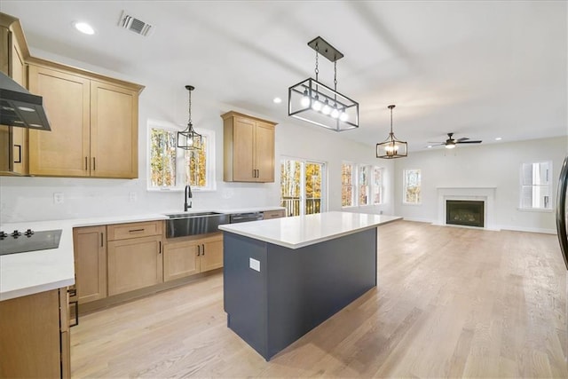 kitchen with visible vents, decorative light fixtures, a fireplace, black electric cooktop, and a sink