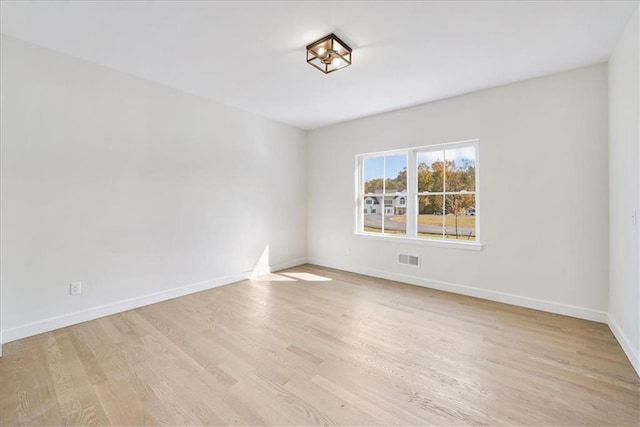 spare room with visible vents, baseboards, and light wood-style floors