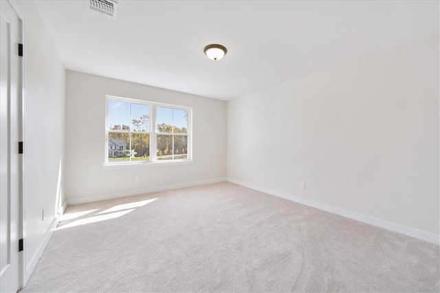 spare room with carpet, visible vents, and baseboards