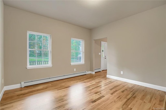 spare room featuring light wood-type flooring and a baseboard heating unit