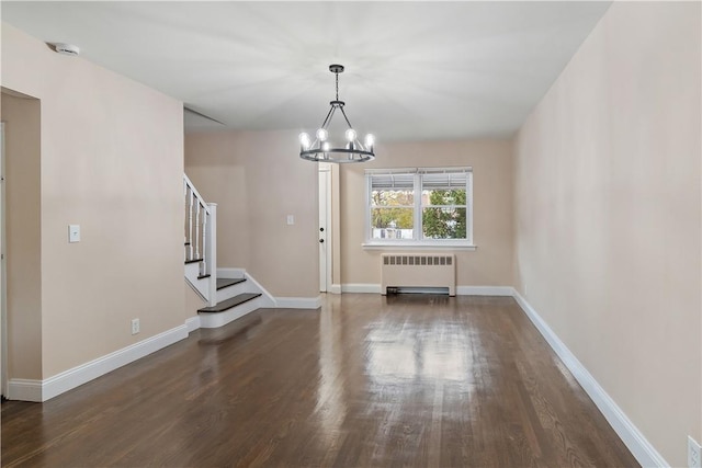 unfurnished living room with radiator heating unit, dark wood-type flooring, and a chandelier