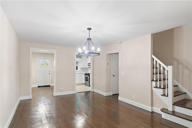 unfurnished living room with dark hardwood / wood-style flooring and a notable chandelier