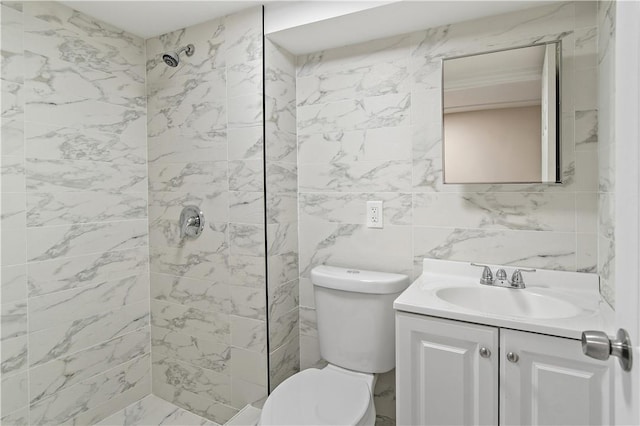 bathroom with a tile shower, vanity, and toilet