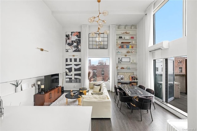 living room with a wall mounted air conditioner, a high ceiling, dark hardwood / wood-style flooring, and a wealth of natural light