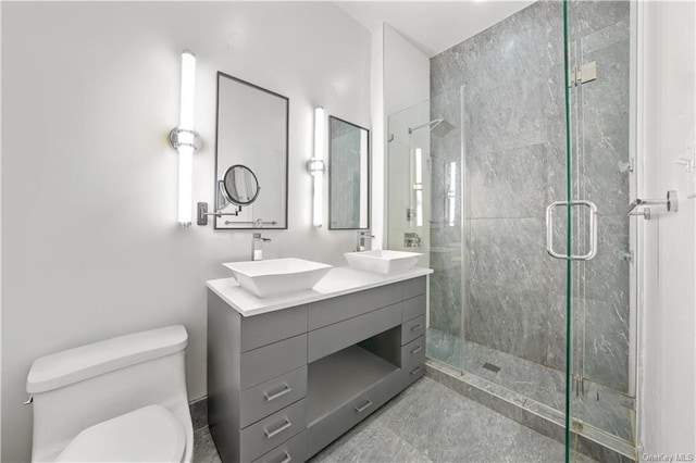 bathroom featuring vanity, toilet, and a shower with shower door