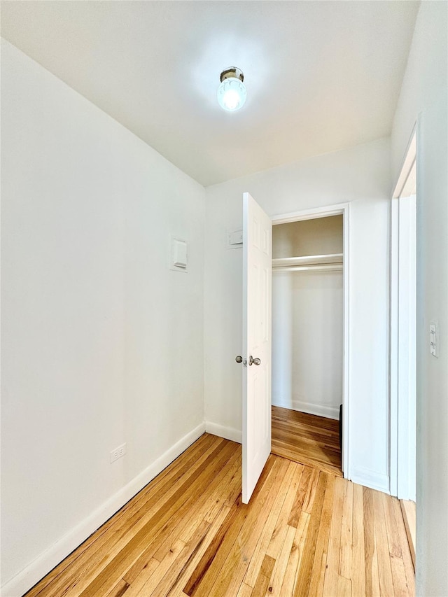 unfurnished bedroom with light wood-type flooring and a closet