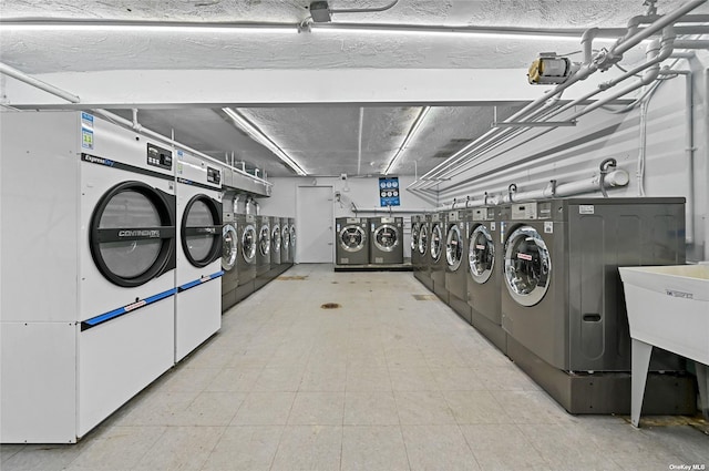 laundry room featuring washing machine and clothes dryer and sink