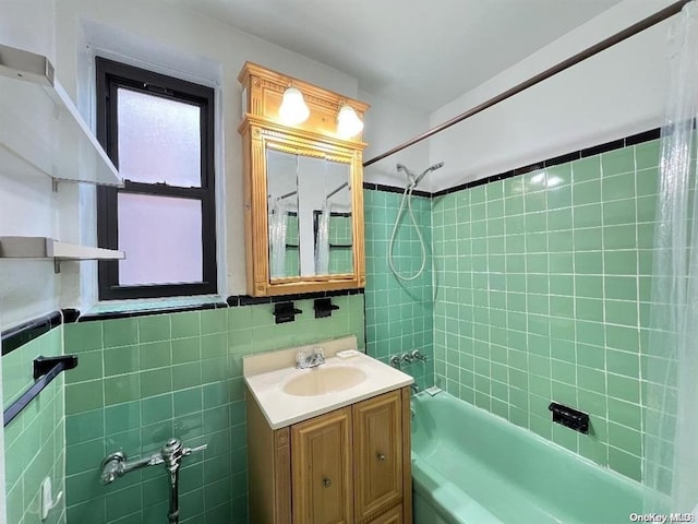 bathroom featuring tiled shower / bath, vanity, and tile walls