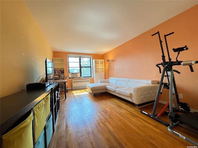 living room featuring radiator heating unit, light wood-type flooring, and cooling unit