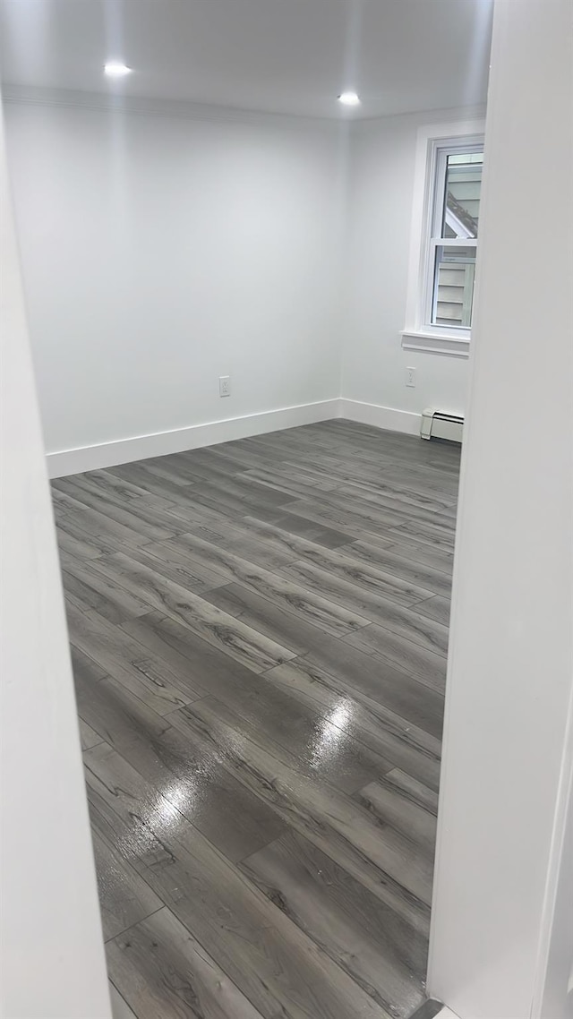 spare room featuring dark hardwood / wood-style floors and a baseboard heating unit