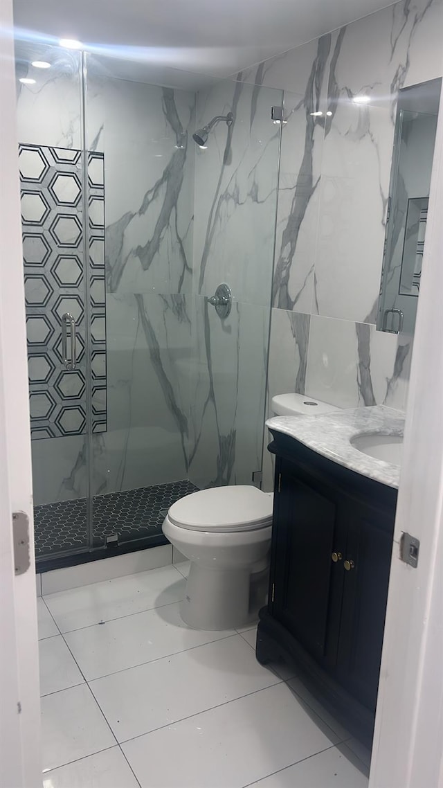 bathroom with tile patterned floors, vanity, toilet, and walk in shower