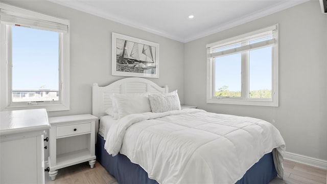 bedroom featuring crown molding and light hardwood / wood-style floors