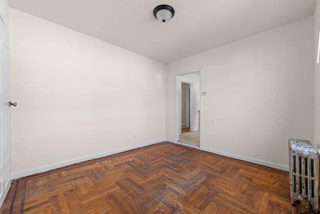 empty room with parquet floors and radiator heating unit