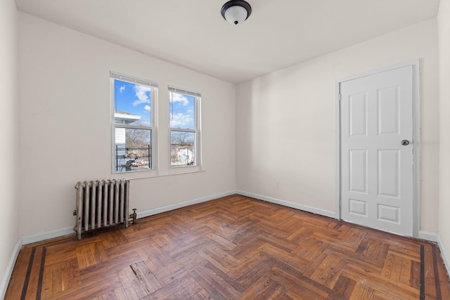 unfurnished room with dark parquet flooring and radiator