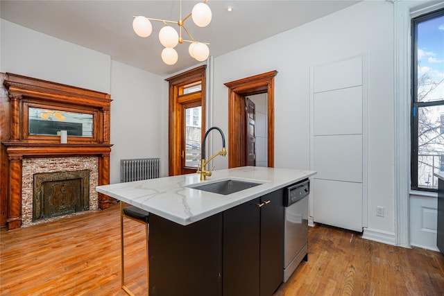 kitchen with sink, a healthy amount of sunlight, hanging light fixtures, stainless steel dishwasher, and a center island with sink