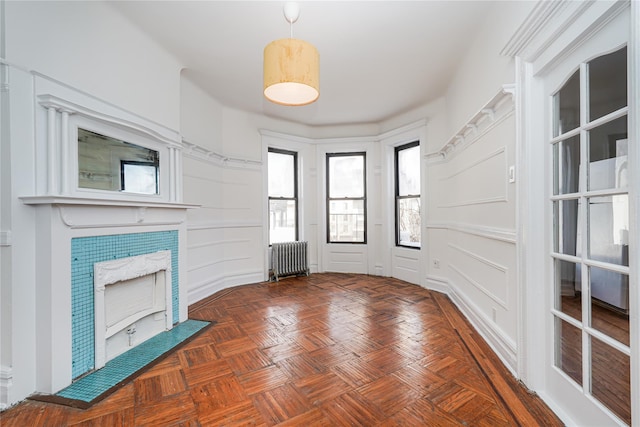 unfurnished living room with dark parquet floors and radiator