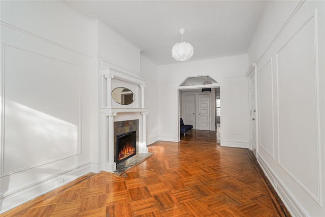 unfurnished living room with a tile fireplace and parquet floors