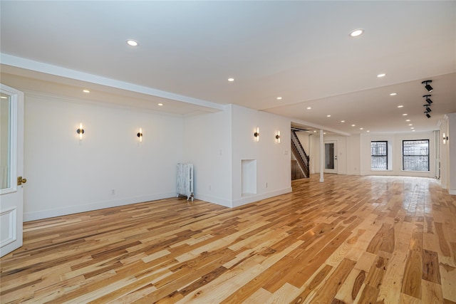 unfurnished living room featuring light wood-type flooring and radiator