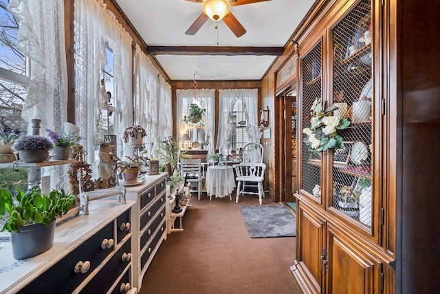 sunroom / solarium featuring beam ceiling and ceiling fan