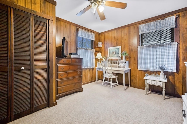 carpeted office featuring ceiling fan and wooden walls