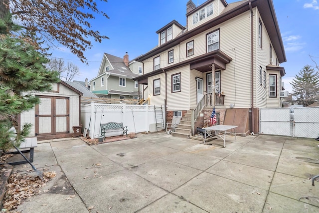 back of property featuring a patio and a shed