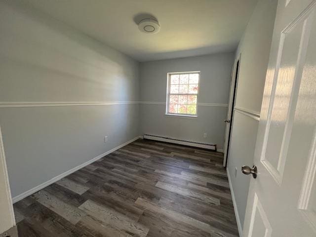 spare room with dark hardwood / wood-style floors and baseboard heating