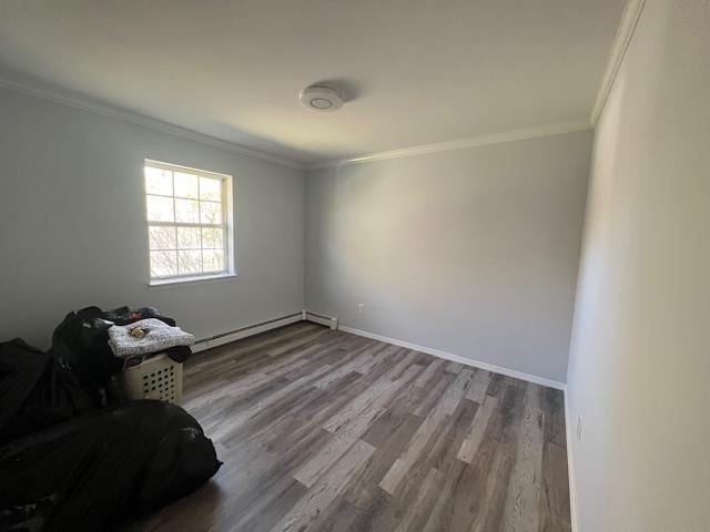 spare room with wood-type flooring, a baseboard radiator, and crown molding