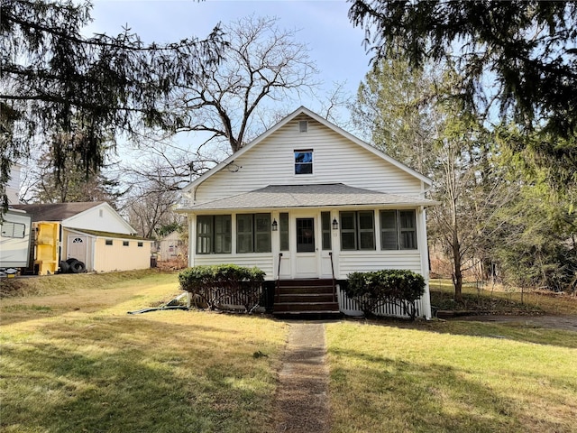 view of front of house with a sunroom and a front yard