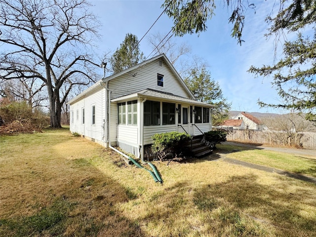 back of property with a sunroom and a lawn