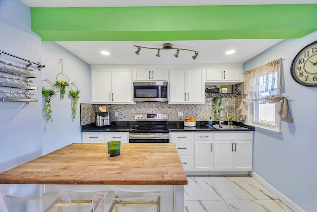 kitchen with white cabinets, appliances with stainless steel finishes, backsplash, and sink