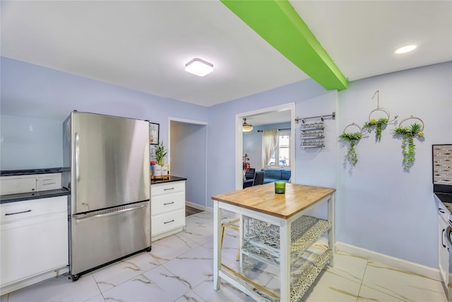 kitchen featuring white cabinets and stainless steel fridge