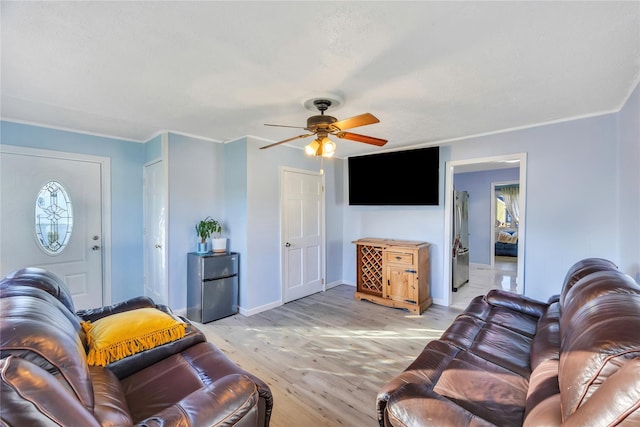 living room featuring light hardwood / wood-style floors, ceiling fan, and ornamental molding