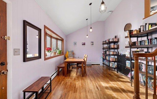 dining room with light wood-type flooring, lofted ceiling, and baseboard heating