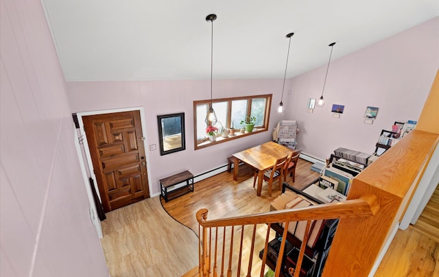 interior space with hardwood / wood-style flooring, a baseboard heating unit, and vaulted ceiling