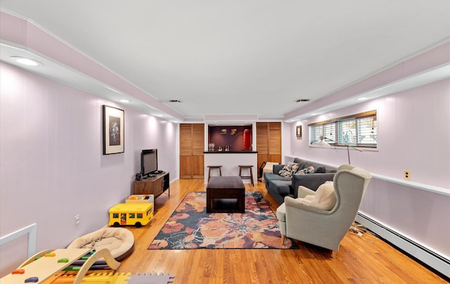 living room with hardwood / wood-style floors and a baseboard heating unit