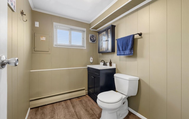 bathroom with baseboard heating, crown molding, vanity, and hardwood / wood-style flooring