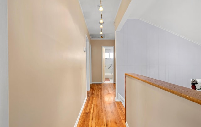 hallway featuring light hardwood / wood-style flooring and crown molding