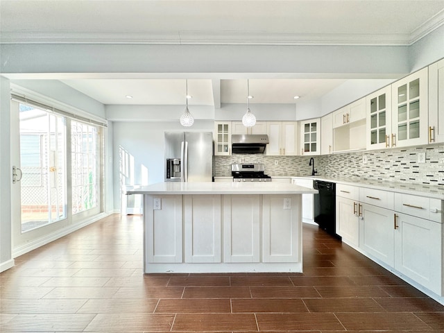 kitchen with decorative light fixtures, white cabinets, appliances with stainless steel finishes, and a center island