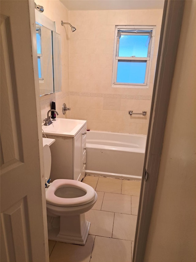 full bathroom featuring tile patterned flooring, vanity, toilet, and tiled shower / bath