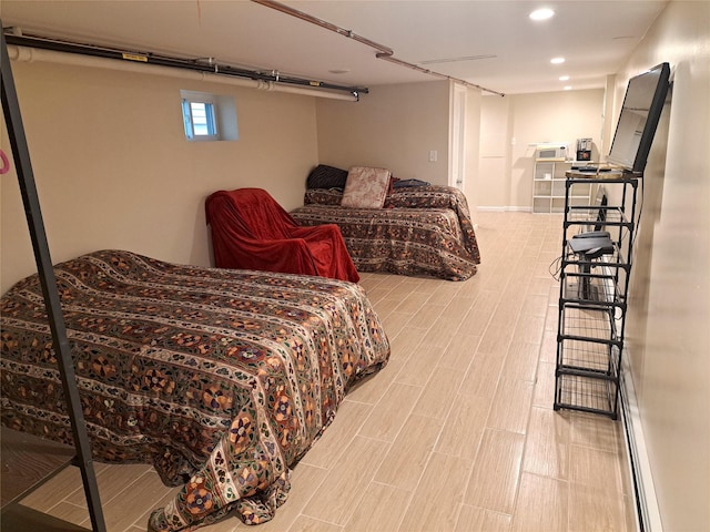 bedroom with a baseboard radiator and hardwood / wood-style flooring