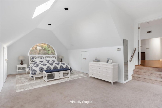 carpeted bedroom featuring vaulted ceiling with skylight