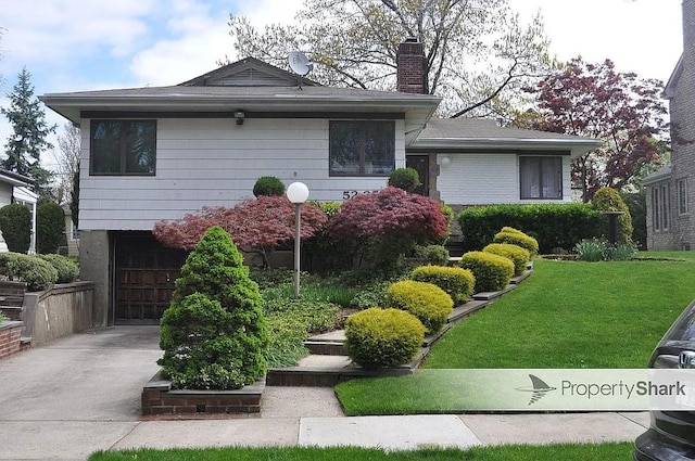 view of front of home featuring a garage and a front lawn