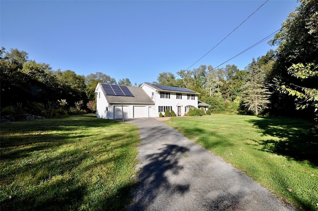 view of front of house with solar panels and a front yard