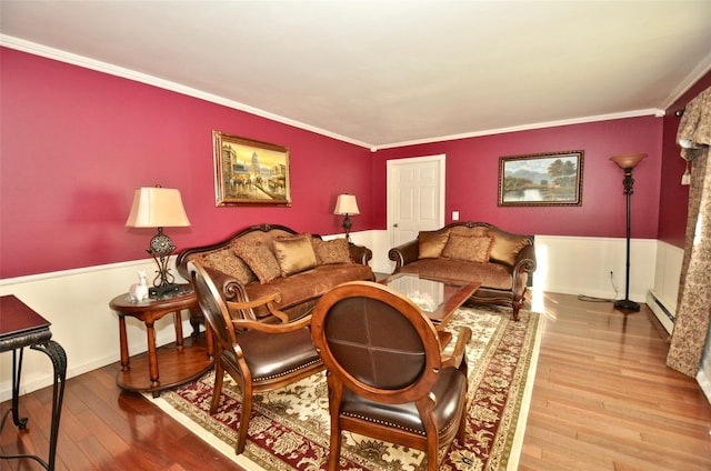 living room featuring hardwood / wood-style floors, baseboard heating, and ornamental molding