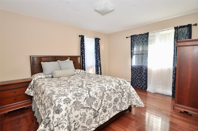 bedroom with hardwood / wood-style floors and multiple windows