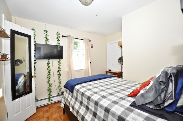 bedroom with dark parquet flooring and a baseboard radiator