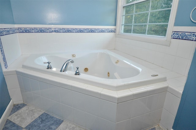 bathroom with a relaxing tiled tub and tile patterned floors